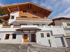 a large white house with a wooden roof at MarieindenBergen - Ihre private Unterkunft in Saalbach-Hinterglemm