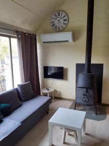 a living room with a couch and a fireplace with a clock at Loft rénové au calme à la campagne pour famille in Hastière-par-delà