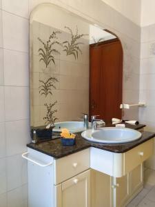 ein Badezimmer mit einem Waschbecken und einem großen Spiegel in der Unterkunft A casa di Leda in Sarzana