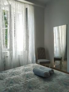 a bed with a towel on it in a room with a window at A casa di Leda in Sarzana