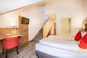 Habitación de hotel con 2 camas y escalera en Hotel Wilder Mann en Steinach am Brenner