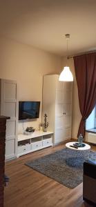 a living room with a television and white cabinets at Studio flat in a historical XIX c. building. in Kaunas