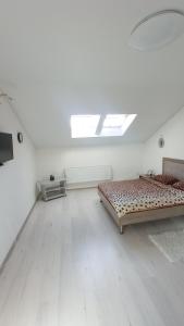 een witte kamer met 2 bedden en een dakraam bij Apartament Buk in Rivne