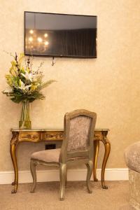 a vase of flowers sitting on a table with a chair at 30 James Street in Liverpool