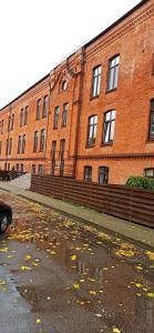 un gran edificio de ladrillo frente a una calle en Studio flat in a historical XIX c. building. en Kaunas
