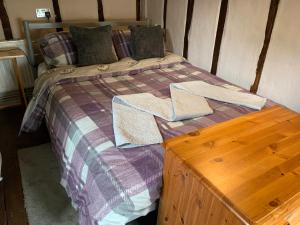 a bed with two towels on it with a wooden table at Myrtle cottage in Dickleburgh