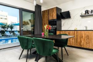 a dining room with a table and green chairs at Olive Tree mansion in Vir