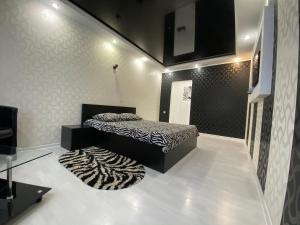 een slaapkamer met een bed en een tapijt op de vloer bij Lux City Center in Kvartal 95 in Krivoy Rog