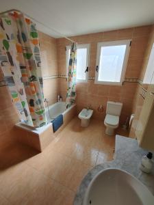 a bathroom with a toilet and a tub and a sink at CASA CLIMATIZADA VACACIONAL in Villalonga