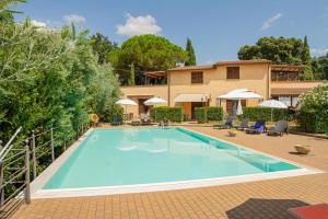 a swimming pool in front of a house at Matteo's Apartments in Guardistallo