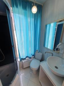 a bathroom with a toilet and a sink and a mirror at Apartment 31 August in Chişinău