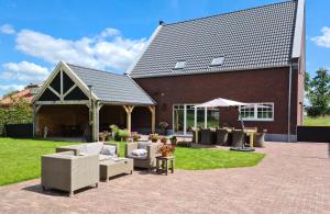 a patio with couches and chairs in front of a building at B&B 't Mjeels Pierke in Meerle