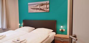 een hotelkamer met een bed met een blauwe muur bij Residenz Seeblick 3 Balkon mit Zugang zum Garten in Ostseebad Sellin
