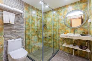 a bathroom with a shower and a toilet and a sink at 山水忆阁酒店 in Yangshuo