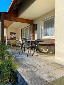 eine Terrasse mit Stühlen, einem Tisch und einer Bank in der Unterkunft Ferienwohnungen / Ferienhaus Dillingen an der Donau in Dillingen an der Donau