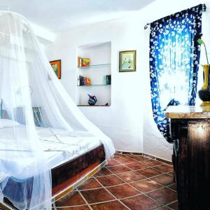 a bedroom with a bed with a mosquito net at Şato Triopia Butik Otel in Yaka