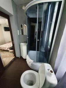 W łazience znajduje się biała toaleta i prysznic. w obiekcie Bucuresti Apartment Studio w Kiszyniowie