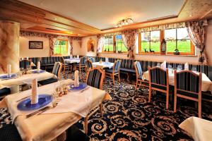 a restaurant with white tables and chairs and windows at Hotel Galtürerhof in Galtür