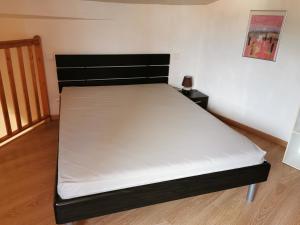 a bed in a room with a white mattress at Appartement duplex in Le Boulou