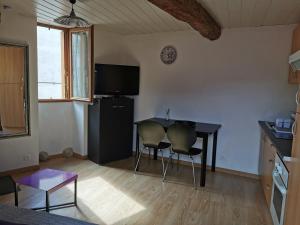 a living room with a table and chairs and a television at Appartement duplex in Le Boulou +3 photos