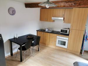 a small kitchen with a black table and chairs at Appartement duplex in Le Boulou