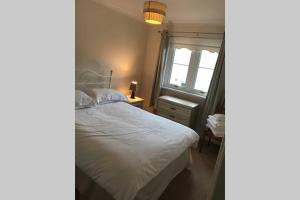 um quarto com uma cama branca e uma janela em Kingseat 3 Bed Home With Fast Fibre WiFi &Parking em Newmacher