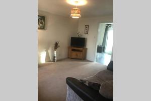 a living room with a couch and a television at Kingseat 3 Bed Home With Fast Fibre WiFi &Parking in Newmacher