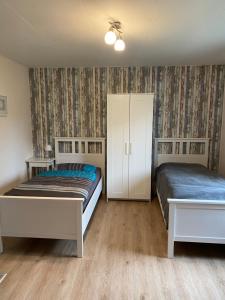 1 Schlafzimmer mit 2 Betten und einem weißen Schrank in der Unterkunft Fewo Ramin in Felchow