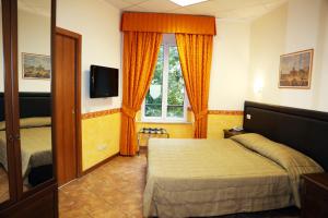ローマにあるロカンダ サン コジマートのベッドとテレビが備わるホテルルームです。