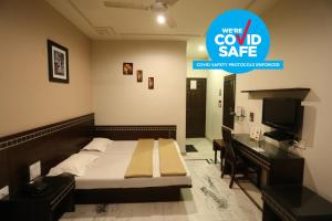 a hotel room with a bed and a television at Smyle Inn - 3 minutes walk From New Delhi Railway Station in New Delhi