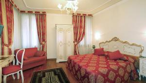 1 dormitorio con 1 cama roja y 1 silla en Hotel San Luca Venezia, en Venecia