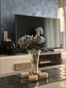 Mavrovo Twins Apartment في مافروفو: مزهرية من الزهور على طاولة مع الشموع