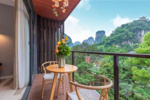 a balcony with a table with a vase of flowers at 山水忆阁酒店 in Yangshuo +38 photos