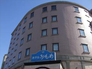 a building with a blue sign in front of it at Seaside Hotel Kamome in Hakodate