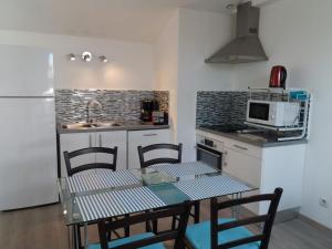 een keuken met een tafel en stoelen en een magnetron bij Appartements Au Cros De Cagnes in Cros-de-Cagnes
