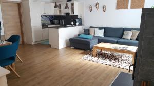 ein Wohnzimmer mit einem blauen Sofa und einem Tisch in der Unterkunft Appartementhaus Zraunig in Flattach