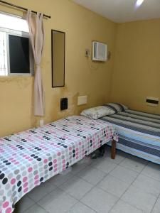 a bedroom with two beds and a window at Pousada Formosa Baia in Baía Formosa