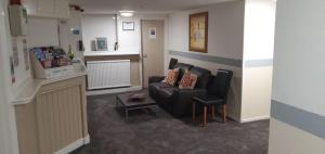 a living room with a couch and a chair at Brookfield Hotel in Leeds