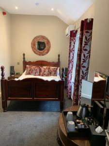 a bedroom with a wooden bed with red pillows at The Peacock in Bakewell