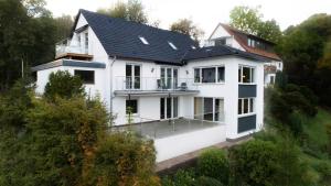 una casa bianca con il tetto nero di Harz Living - Ferienwohnungen mit Traumblick a Bad Lauterberg