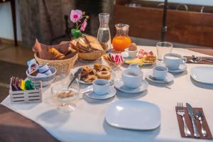 uma mesa com uma toalha de mesa branca com alimentos para pequeno-almoço em Residenza d'Epoca Pietra Di Ponente em Ciampino
