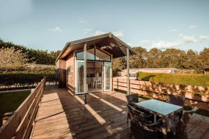 a tiny house with a deck and a table at Little Eden Country Park, Bridlington with Private Hot Tubs in Bridlington