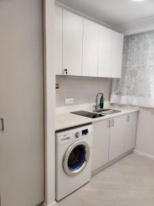 a kitchen with a washing machine and a sink at Migdal Luxury Suites Netanya J29 in Netanya