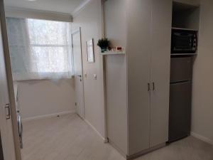 a room with a kitchen with a refrigerator and a window at Migdal Luxury Suites Netanya J29 in Netanya