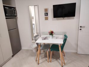 a small kitchen with a white table and chairs at Migdal Luxury Suites Netanya J29 in Netanya