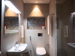 uma casa de banho com um lavatório, um WC e um chuveiro em Saray Prime Suites em Kuwait