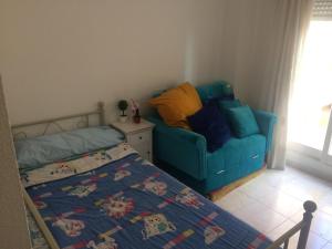 una camera con un letto e un divano blu di Málaga Habitación en Apartamento Carlos Haya a Málaga