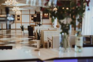 a lobby with tables and chairs and a chandelier at Trio Hotel Restaurant in Ivano-Frankivsk