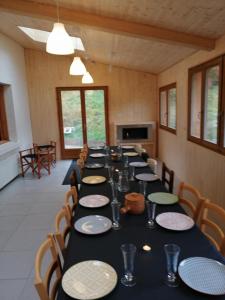 uma mesa longa numa sala com mesas e cadeiras em Gite de L'ours em La Bresse