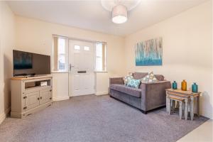 ein Wohnzimmer mit einem Sofa und einem TV in der Unterkunft Guest Homes - Westbrook Court Apartment in Worcester